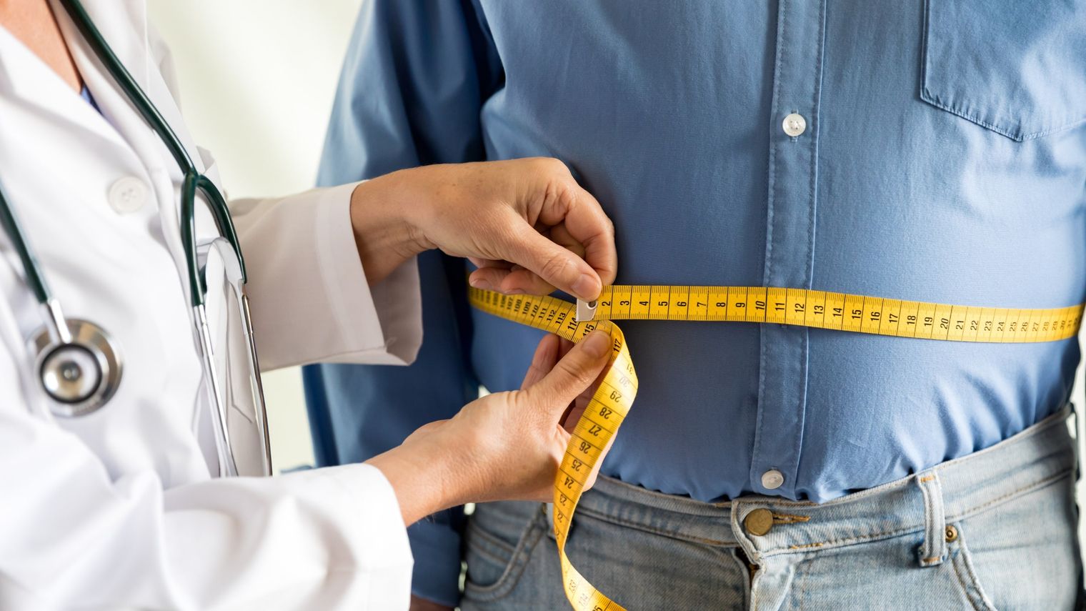 A man gets his measurements taken by a physician.